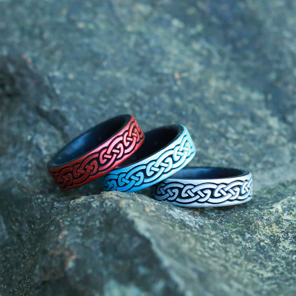Three rings with Celtic knot designs on a stone surface
